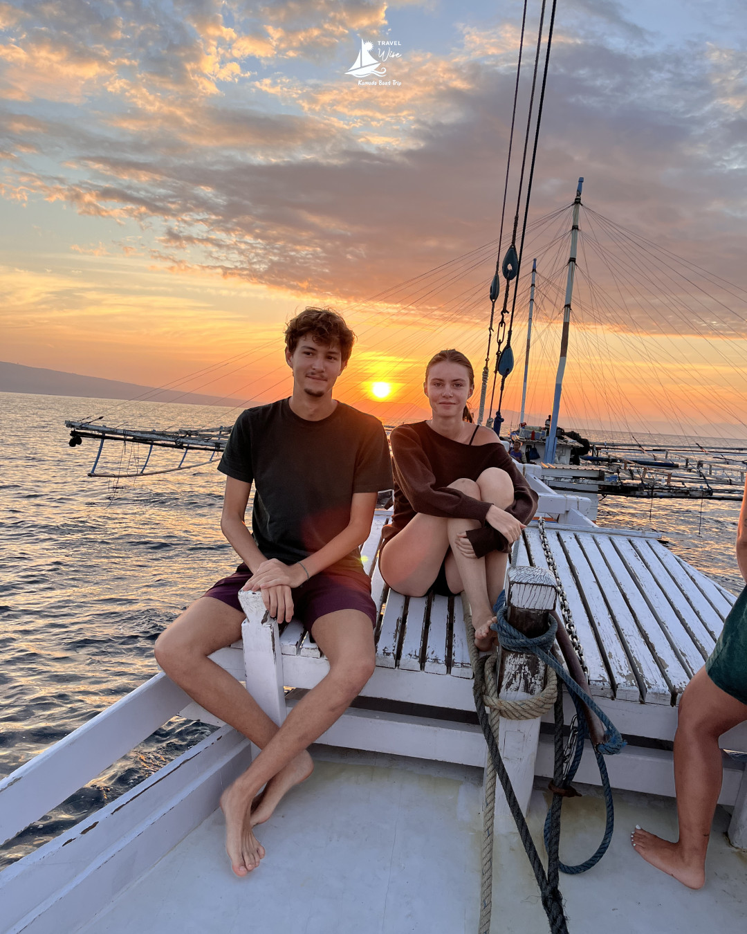 Silhouettes of travelers on the boat against a golden sunset